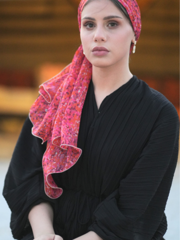 Coral scarf with a delicate pink floral print and golden thread accents.