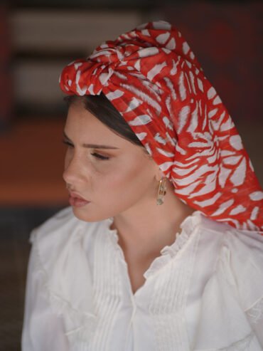 Delicate scarf with a white and red print, accented with gold thread